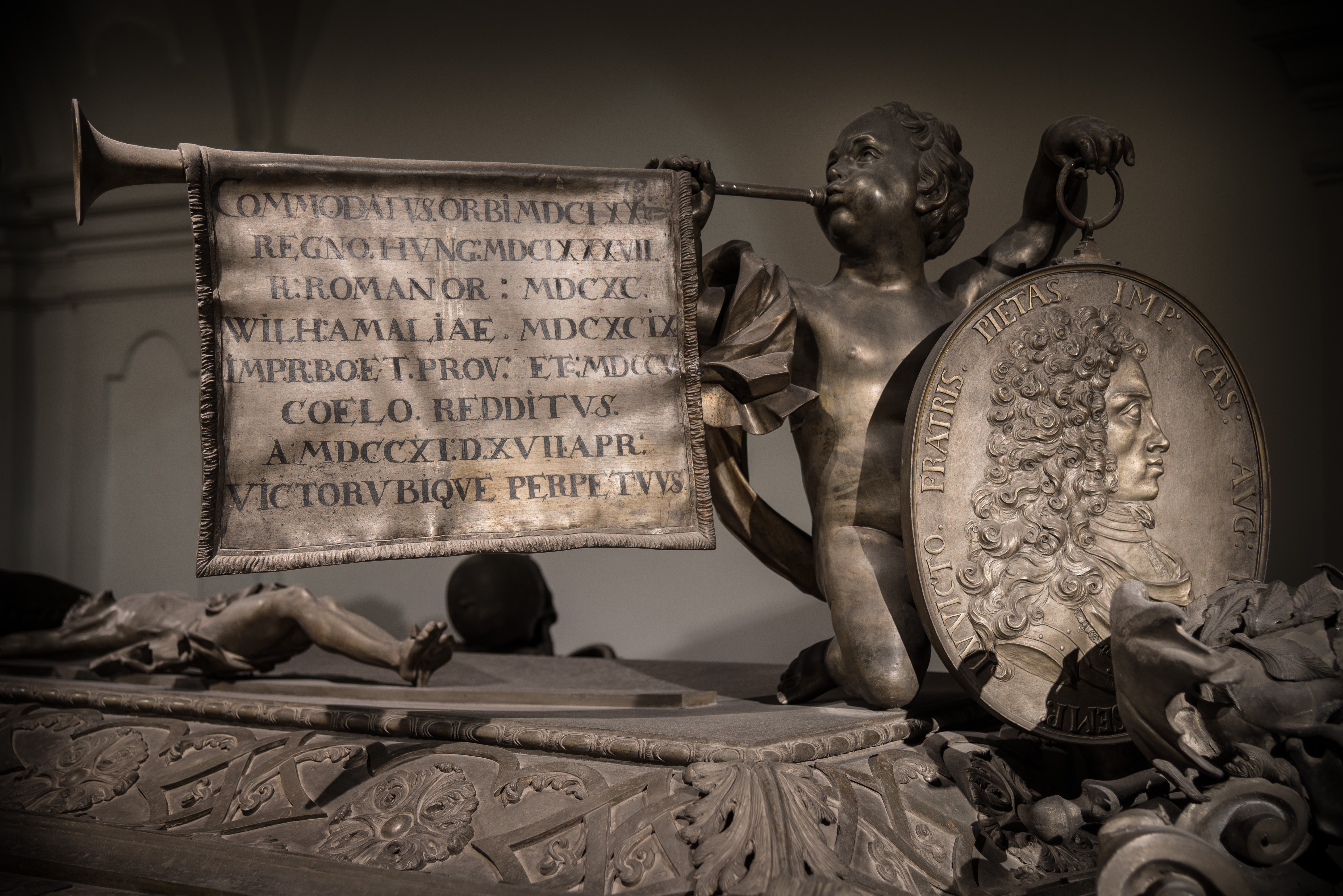 Sargdetails Joseph I., Kaiser, Engel mit Trompete und Porträtmedallion von Joseph I, Kapuzinergruft, Wien, Austria